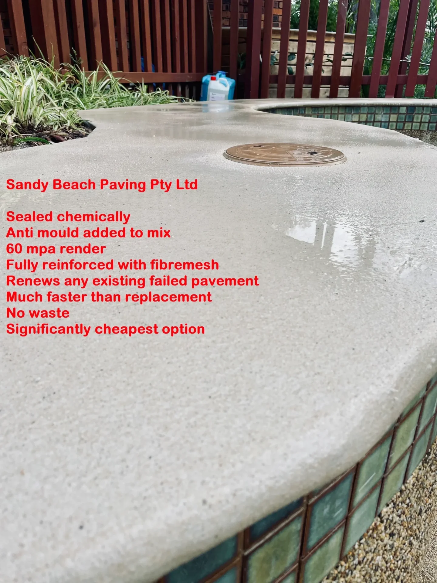 Concrete paving with text and drainage cover.